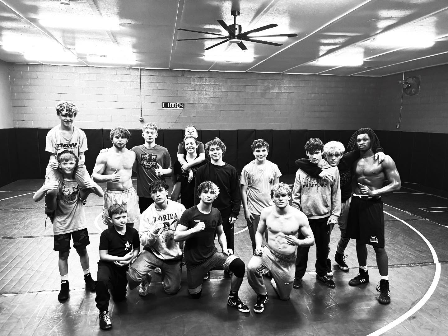 Black and white team photo of Raw West athletes on the mat.