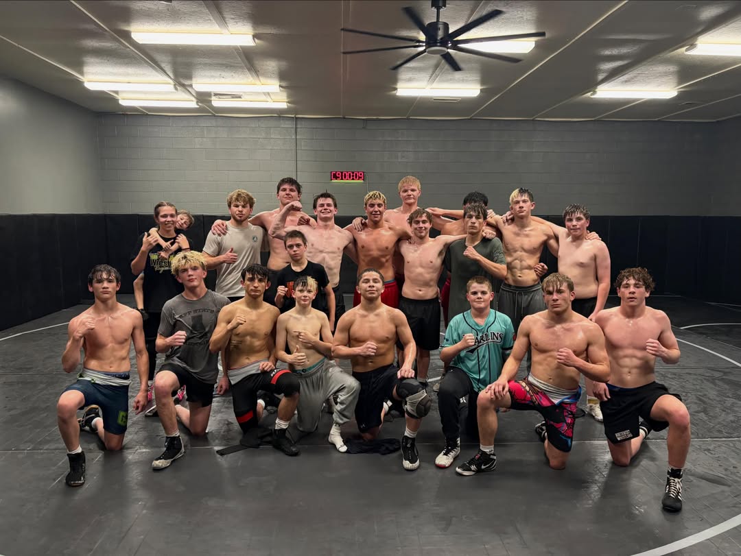 Raw West athletes gathered on the mat after practice, front row kneeling.